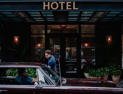 person getting in car in front of hotel