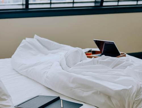Unmade bed with notebook on top