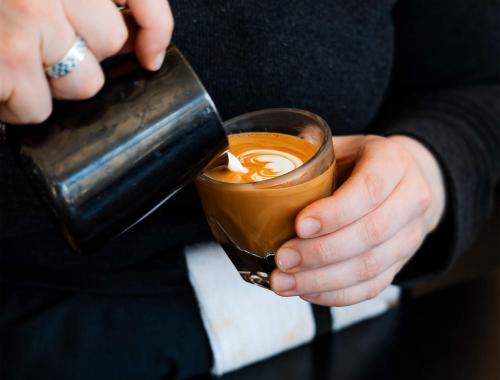 Madcap Coffee latte being poured