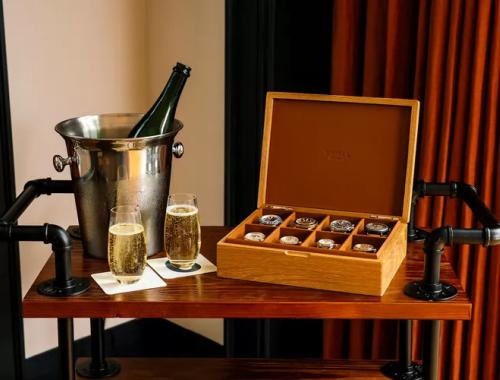 Full Shinola watchbox sitting next to glasses of champagne