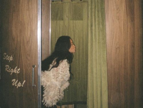 A woman poses in a vintage photo booth