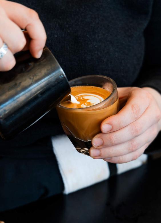 Madcap Coffee latte being poured