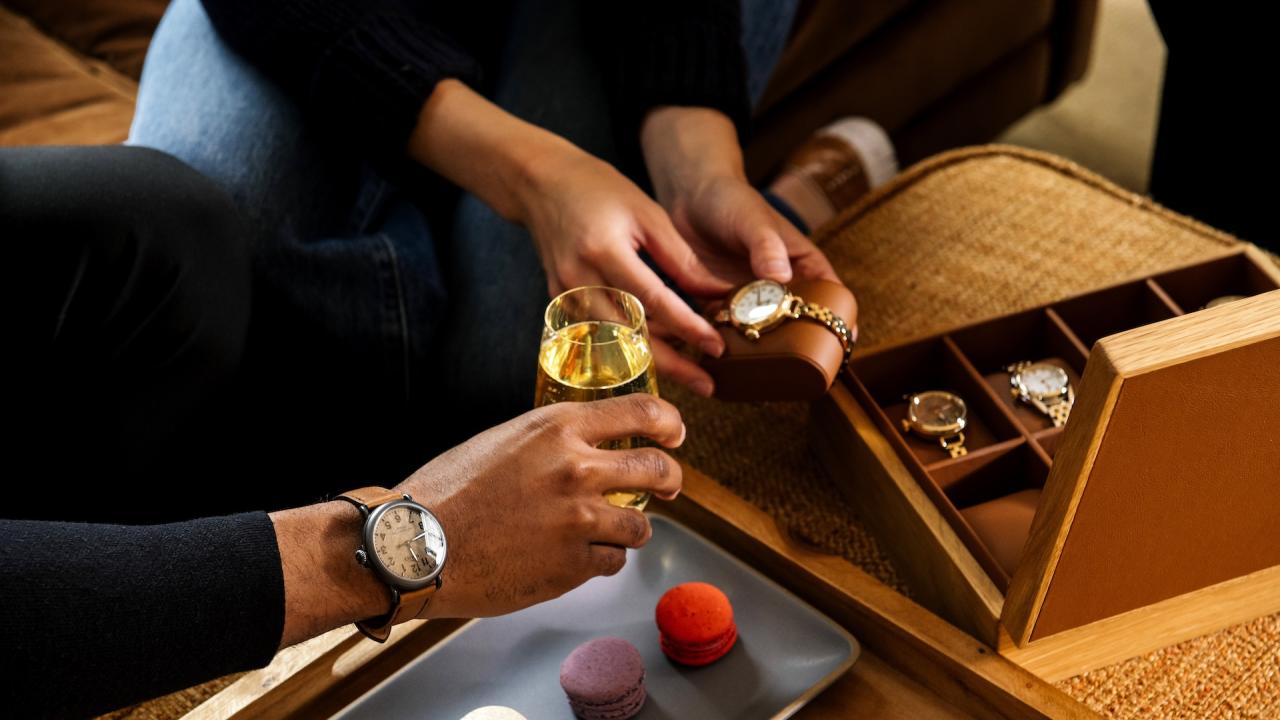 Couple admiring Shinola watches while sipping wine and eating macrons