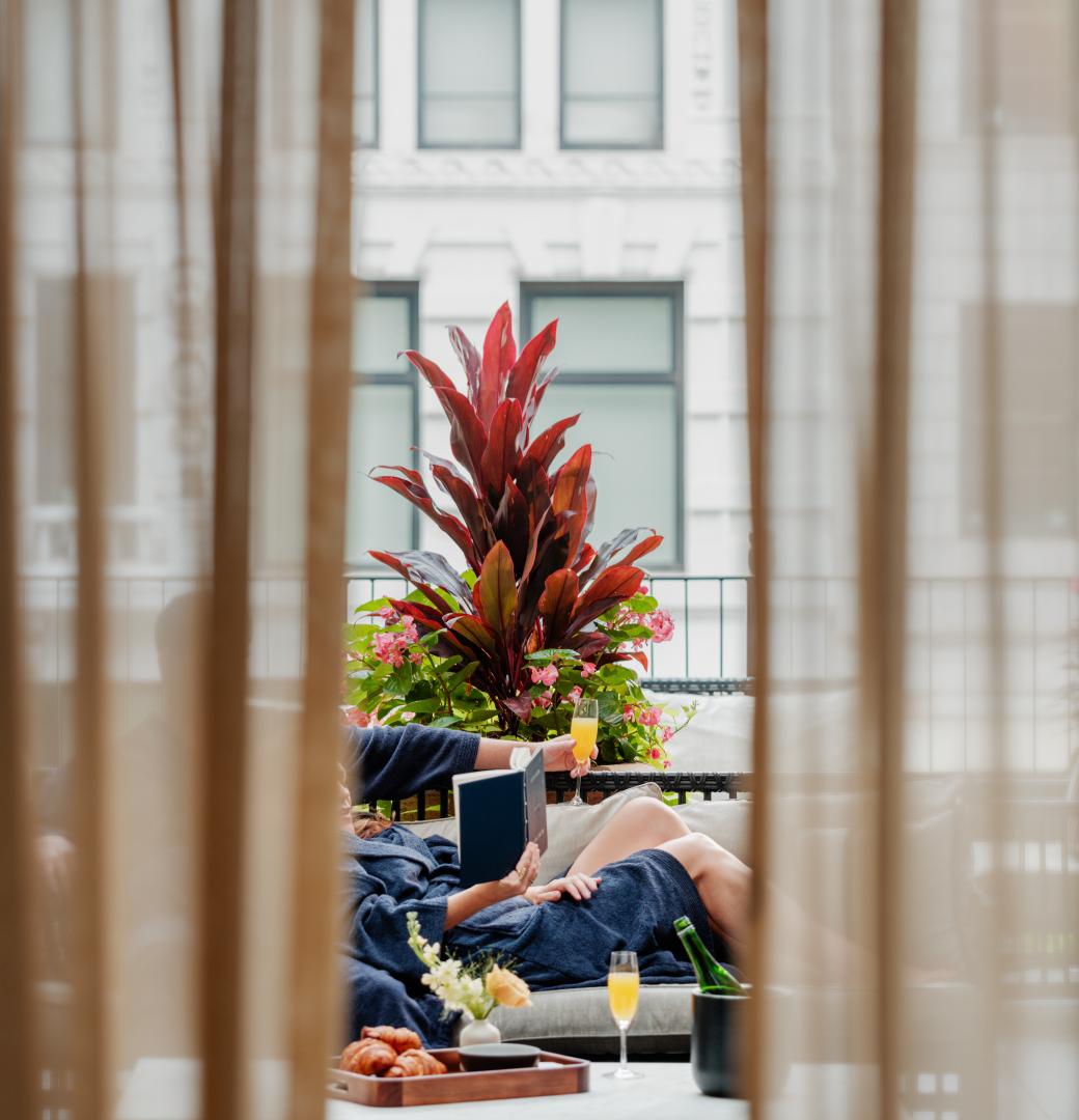 A couple relaxes on a penthouse terrace at the Shinola hotel