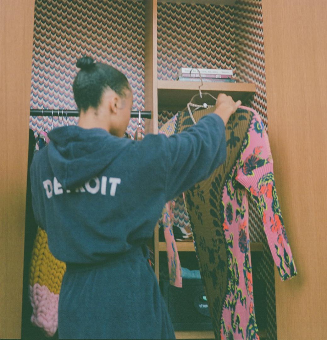 A guest pulls a dress from Coup D'etat from her suite's closet.