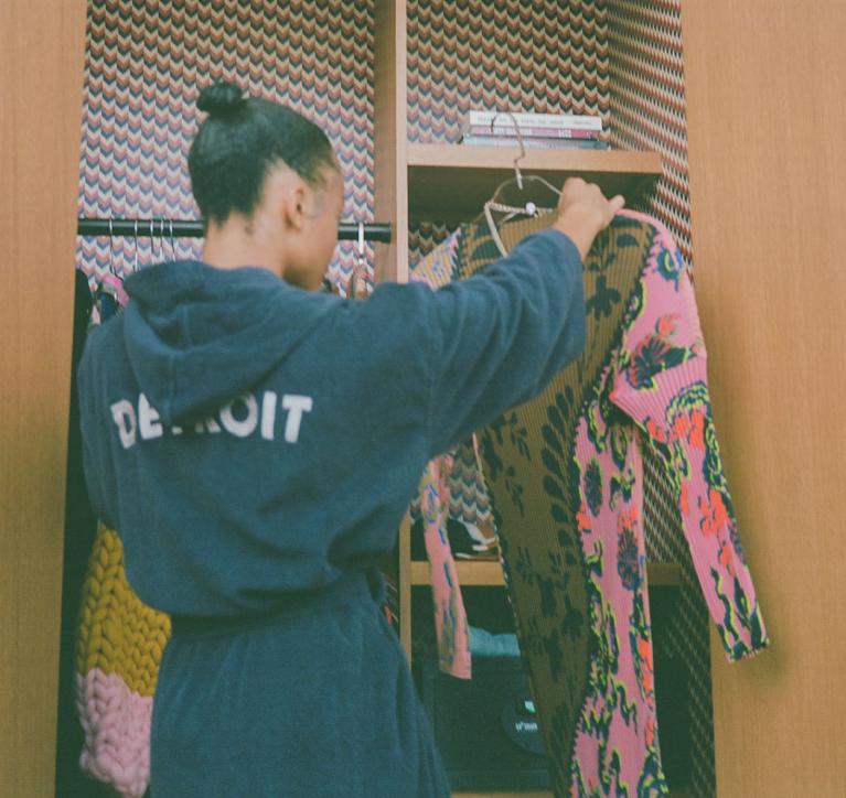 A guest pulls a dress from Coup D'etat from her suite's closet.