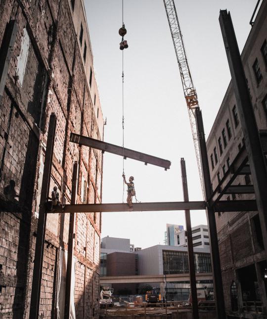 A steel worker places a beam.