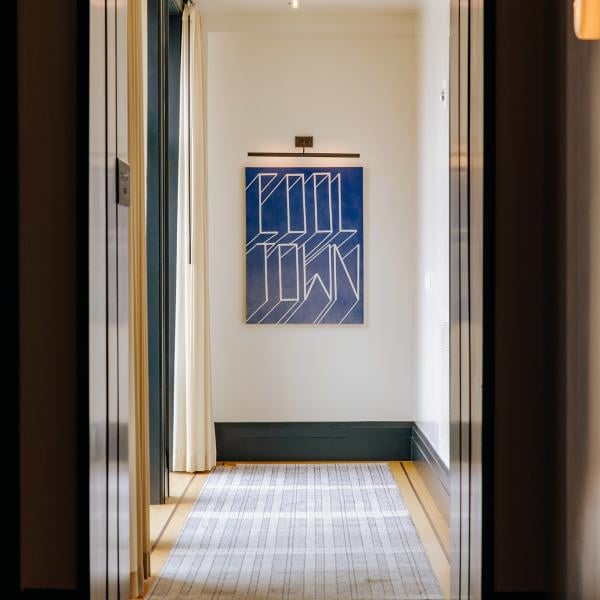 A hallway at Shinola Hotel with a framed posted reading "Cool Town" at the end wall.