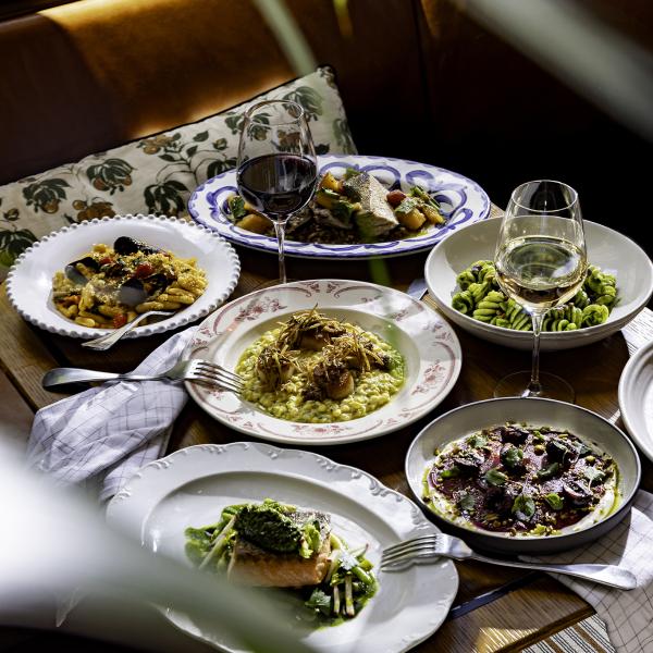 Table with various pasta and seafood dishes and wine glasses at San Morello.